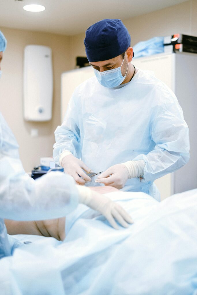 Doctors in protective gear performing surgery in a sterile operating room.